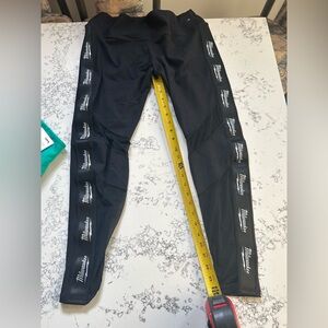 Black Milwaukee stretchy leggings with mesh on bottom side of leg. Size large